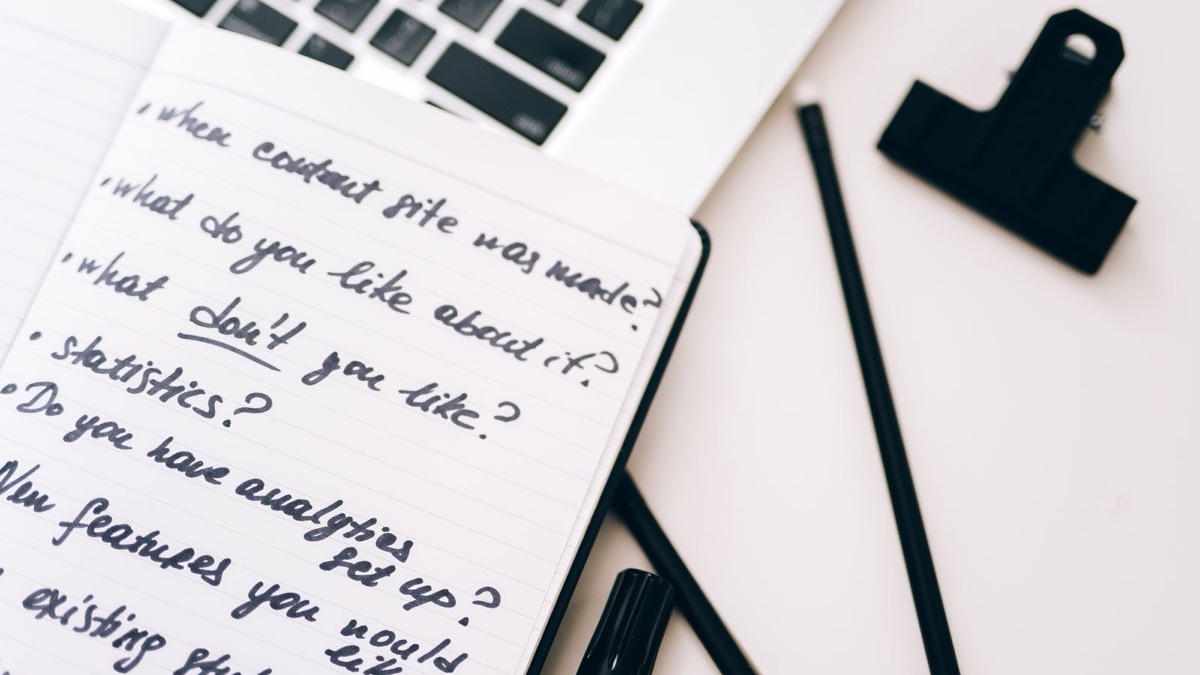 Handwritten notes beside a laptop keyboard