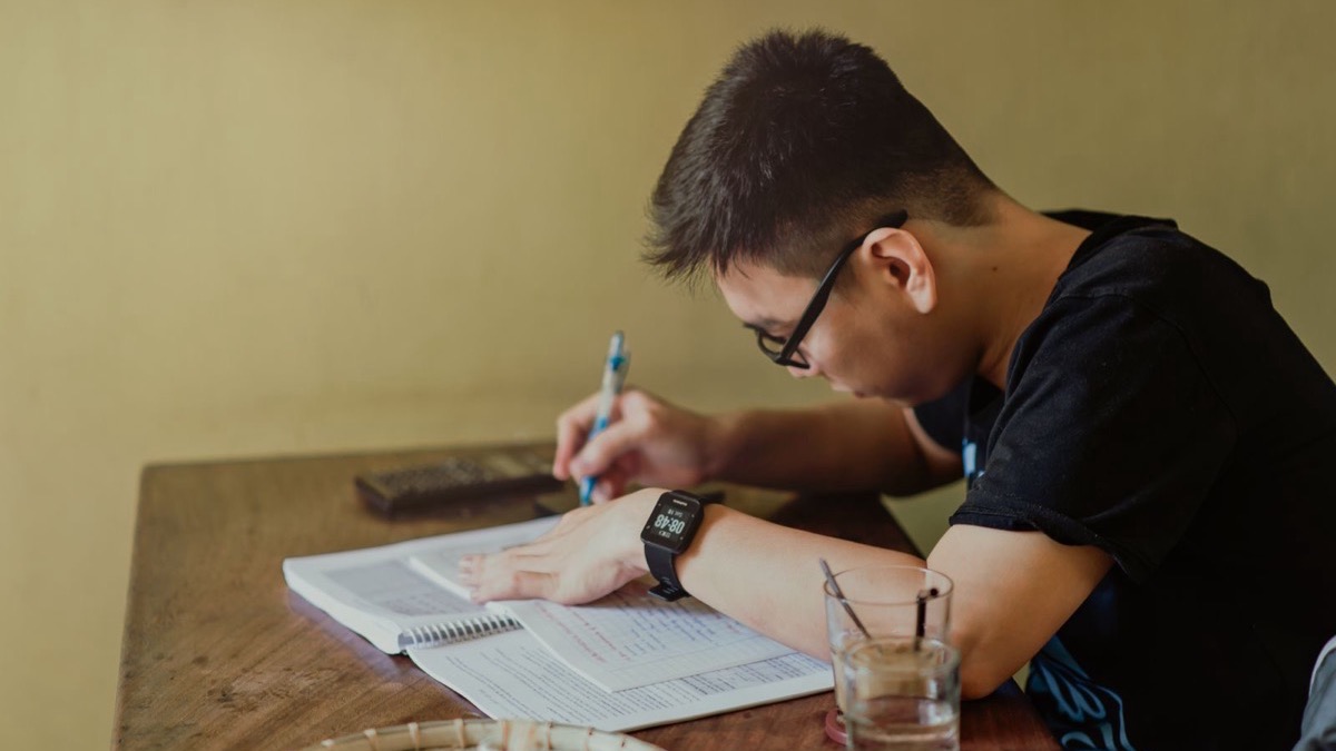 Một sinh viên đang tính toán trên bàn học