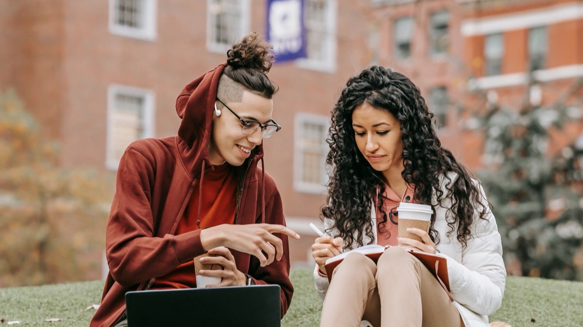 Students sitting on the grass outdoors, studying together