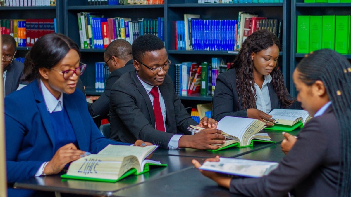 A group of adults studying together at a long table in a library