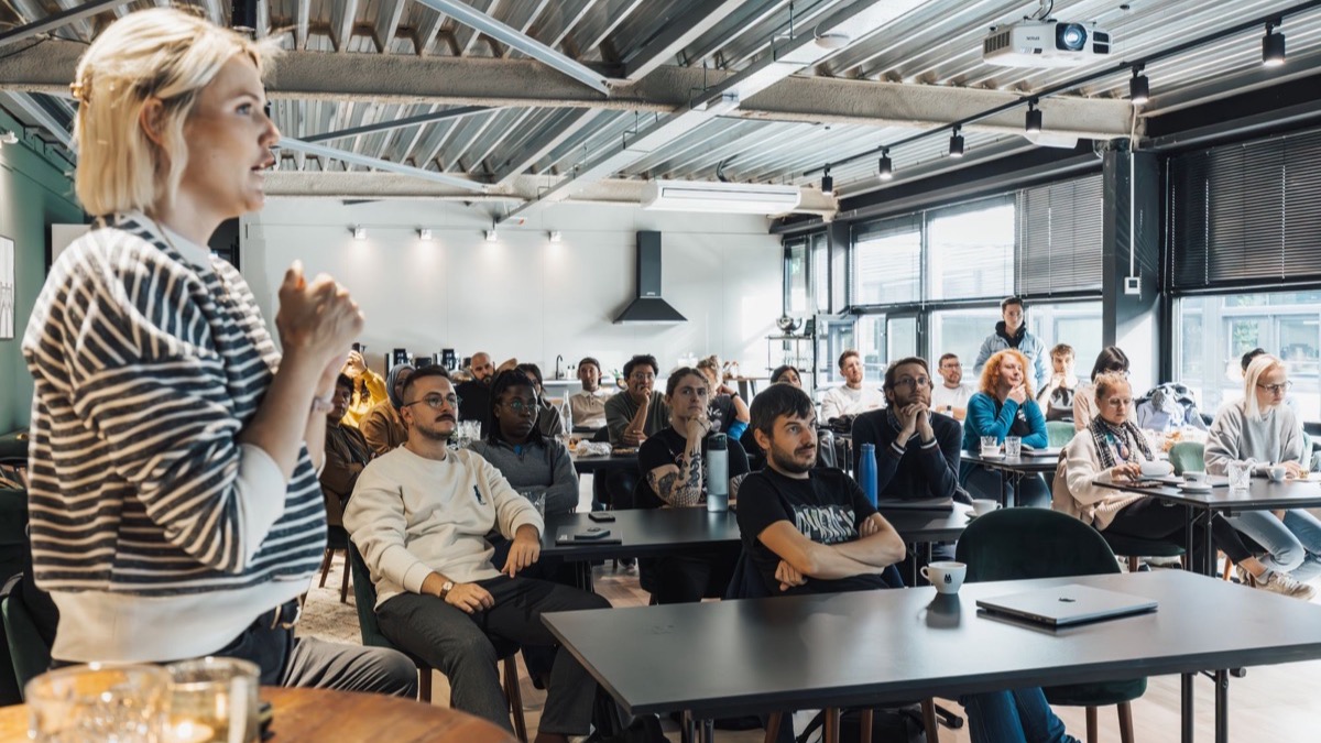 A speaker addressing an audience in a workshop room