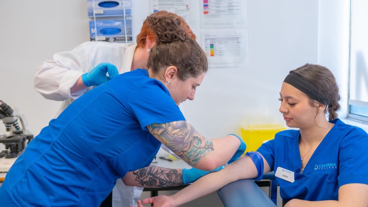 Nursing students practising a clinical procedure under supervision