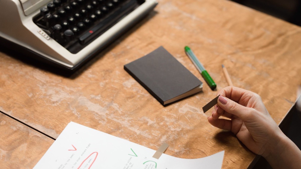 A person checking a printed document page by page at a desk