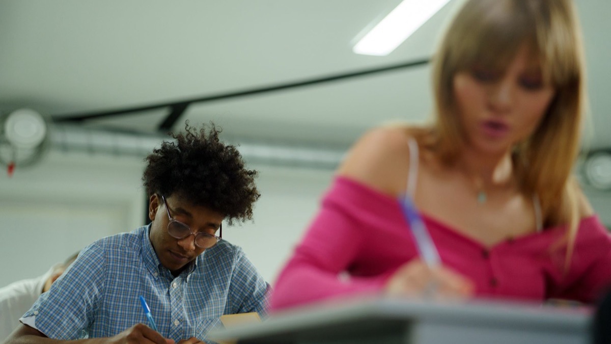 Students writing answers on paper during a classroom test