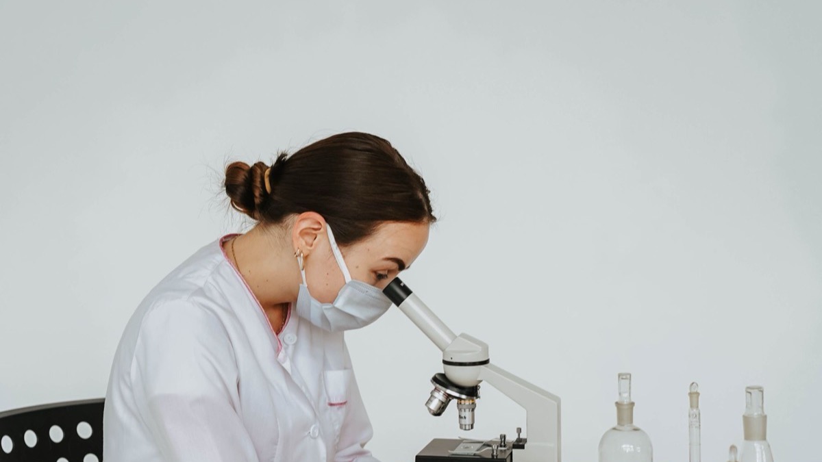 A scientist looking through a microscope during a laboratory experiment