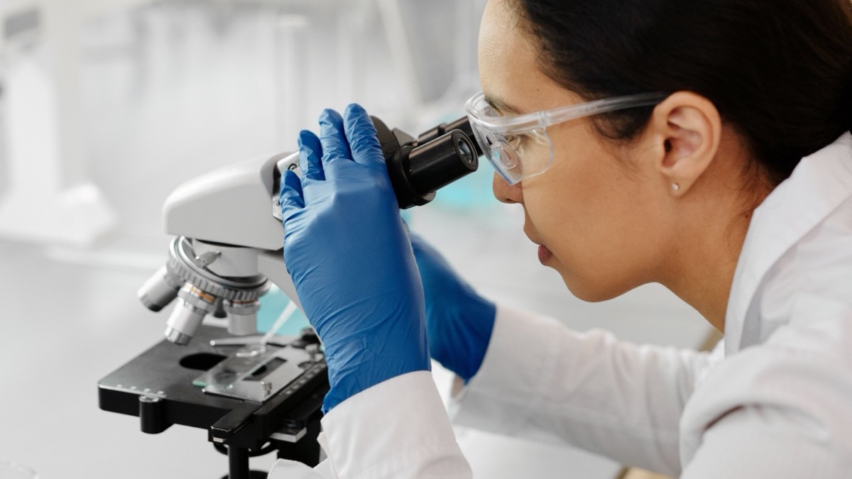 A researcher at a microscope in a laboratory